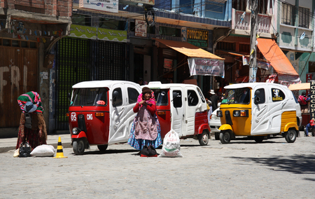BOLIVIA, COROICO, 27 SEPTEMBER 2013 - Tuk Tuk taxi cars in a row and Bolivian women in a street of Coroico, Bolivia, South Americaのeditorial素材