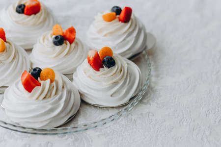 Homemade zephyr or marshmallow, decorated with berries in plate on white table. Marshmallow,...