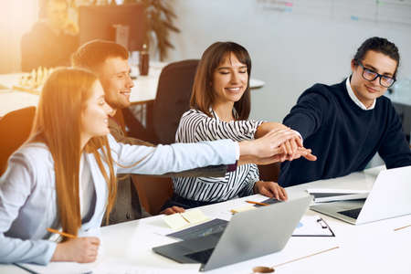 Unity and teamwork. Business people putting their hands together. Coworking.