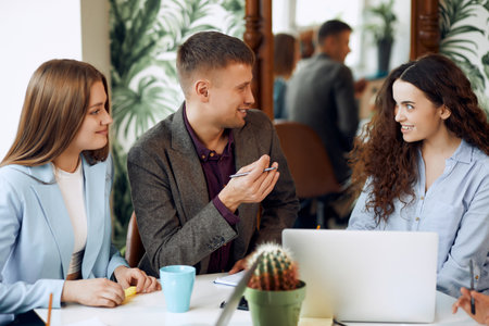 Young designer giving some new ideas about project to his partners in conference room. Business people discussing over new business project in office.の写真素材