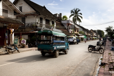 Luang Phabang, Laos, July 21, 2009. In one of the most important street of the city, first thing in the morning, the first vehicles begin to move and the shops and restaurants start to openのeditorial素材