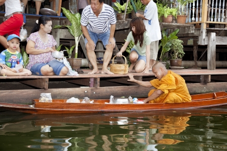 Damnoen Saduak, Thailand-August 9, 2009: Every day very early in the morning, dozens of monks leave with their boats on the canals to begのeditorial素材