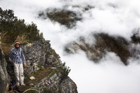 Machupichu PeruJune April 2015: A man is ascending the peak of Machu Picchu surrounded by clouds on three thousand meter highのeditorial素材