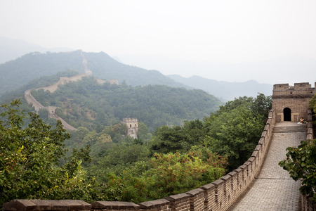 Beijing, China-August 17, 2010: Thousands of tourists visit daily the Chinese wall. A family walking on the Great Wall of China that the horizon is lost in the fogのeditorial素材