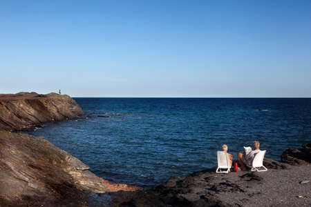 Menorca, Spain-August 27, 2015:  A couple looking at the Mediterranean from a cliff on the Island of...