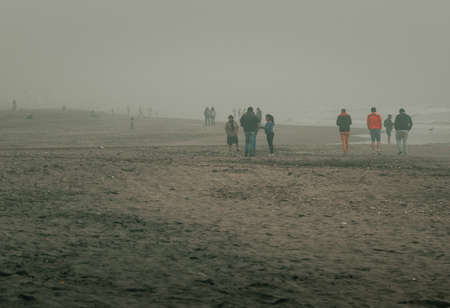La Serena, Chile-August 17, 2014: The fog on La Serena beach occurs very frequently and its inhabitants take the opportunity to walk on the beachの写真素材