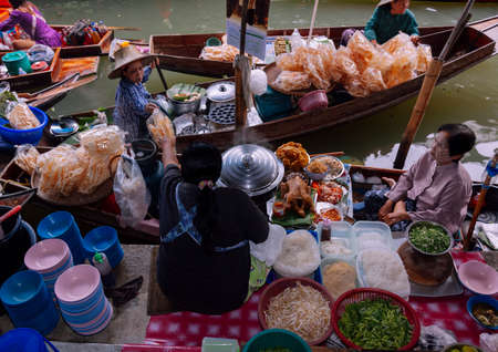 Damnoen Saduak, Thailand-August 9, 2009: People sells souvenirs from his boat at a floating market near Bangkokのeditorial素材