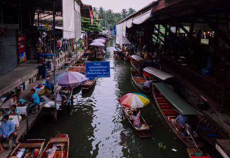 Damnoen Saduak, Thailand-August 9, 2009: People sells souvenirs from his boat at a floating market near Bangkokのeditorial素材