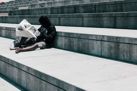 San Franciso, CA, USA-June 21, 2017: Young man reading the newspaper on a sunny day on the San Francisco waterfrontのeditorial素材