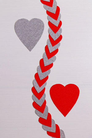 Red And Silver Hearts Apart With String Of Hearts On Textured White