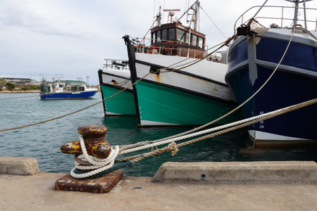 Fishing Trawlers Moored To Bollard On Harbor Quay, Gansbaai, South Africaの写真素材