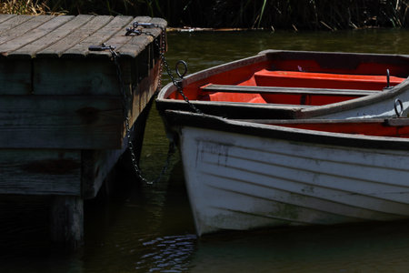 Rowboats Chained To A Wooden Lakeside Pierの写真素材