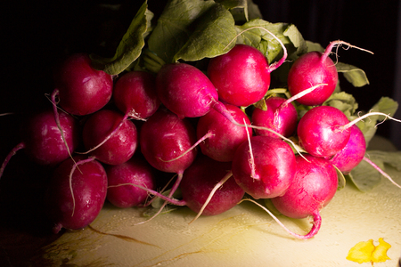 Bundle radishes with leaves on cutting boardの写真素材