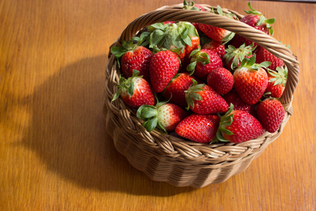 The fresh strawberries in a basket in the board.の写真素材