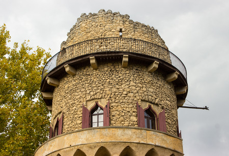 The background is a blue sky with white clouds. The detail of the castle tower is visible in the background.の写真素材