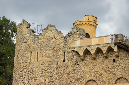 The walls of the old castle. The background is a blue sky with white clouds. The castle tower is visible in the background. Antennas for TV reception are visible on the walls.の写真素材