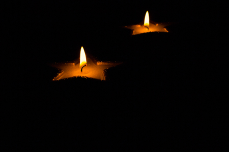 Candles in the shape of star and reflection in the mirror. On the black background with free space for text.の写真素材