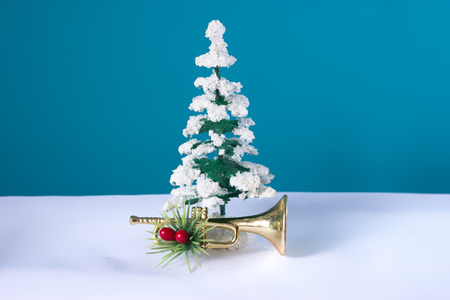 Snowy tree with trumpet festively decorated with a blue background. Christmas still life for musicians.の写真素材
