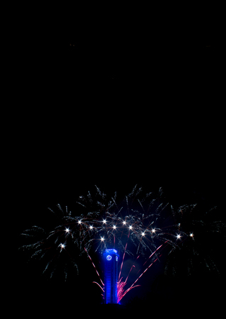 White and red fireworks in Ostrava. The black sky illuminates the fireworks in the background is a blue clock at the Ostrava city hall in the Czech Republic.の写真素材