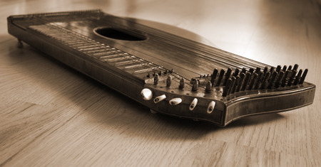 Old zither lying on a wooden table in braun color.の写真素材