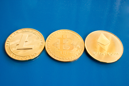 He and blue background are gold coins of a digital crypto currency - litecoin bitcoin and ethereum.の写真素材