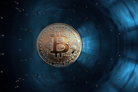 On a blue background in accelerator is gold coin of a virtual digital crypto currency - bitcoin for...