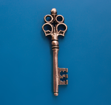 Isolated metal old key on the blue background.の写真素材