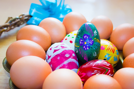 Natural eggs on a brass round tray. On the left is a whip with ribbon. In the middle of the tray are...