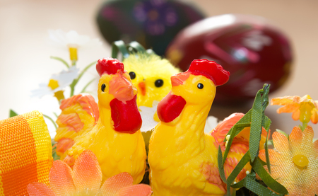 Easter decorations. In the foreground there are two hens behind them is a chicken and in the background is a painted egg.の写真素材