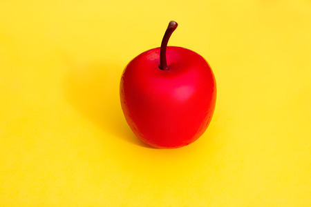 Decoration - red apple on a yellow background in pastel colorsの写真素材