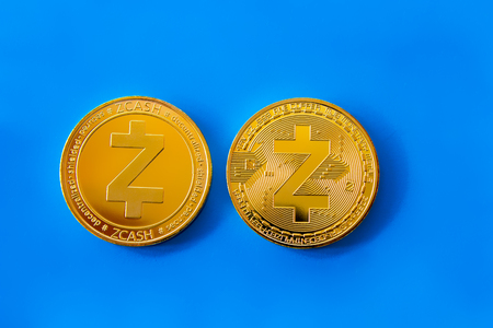 On a blue background is isolated gold coin of a digital crypto  currency - zcash with free space for text. The front and back sides of the gold coin zcash.の写真素材