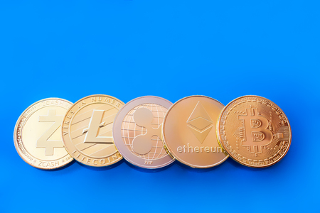 On a blue background are gold coins of a digital crypto currency - zcash litecoin ripple ethereum and bitcoin.の写真素材