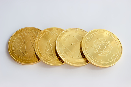 On a white background are the front and back side of gold coins of a digital cryptocurrency - QTUM and EOSの写真素材