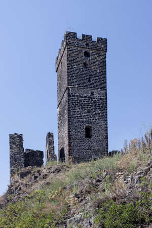 Ruines of hazmburk castle on top of mountain peak of ceske stredohori range. View on the white tower, rocks and walls.の写真素材