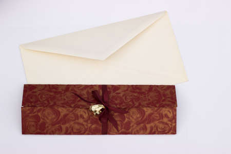 Wedding invitation with gold wedding decorative rings and envelope on a white backgroundの写真素材