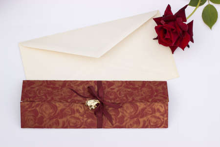 Wedding invitation with gold wedding decorative rings rose and envelope on a white backgroundの写真素材