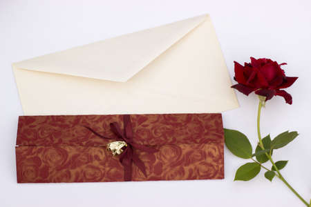 Wedding invitation with gold wedding decorative rings rose and envelope on a white backgroundの写真素材