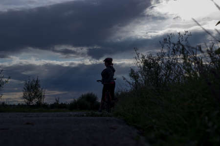 Silhouette of a cyclist in the light of the setting sunの写真素材