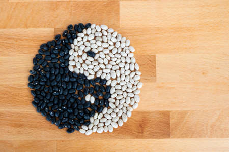 Yin yang beans on wood counterの写真素材