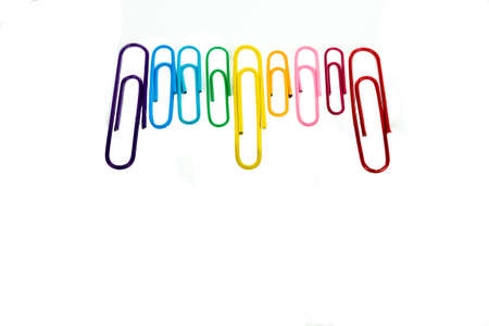 Colorful paperclips in a row on white background