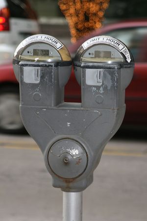 Parking meter in a downtown area with cars going byの写真素材
