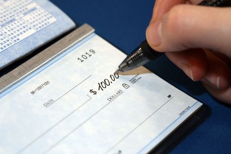 Writing a check in order to pay billsの写真素材