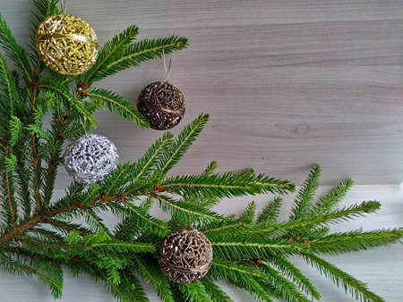 decorate the Christmas tree: Christmas fir and golden carved balls. Christmas decor on light wood backgroundの写真素材