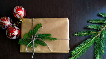 a christmas gift wrapped in craft paper and tied with linen thread with a mock-up next to fir...