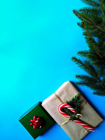 christmas banner on a blue background. Fir branches decorated with glowing garlands with gift boxes...