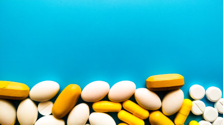 Pills of different colors and shapes on a blue background.
