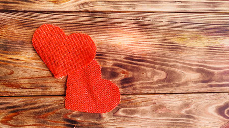 background for valentines day card. hearts of red canvas on a wooden backgroundの写真素材