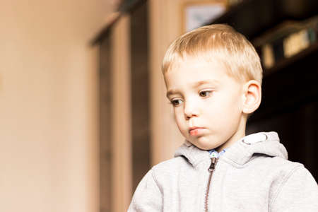 close-up of a pensive caucasian blond-haired three-year-old boyの写真素材