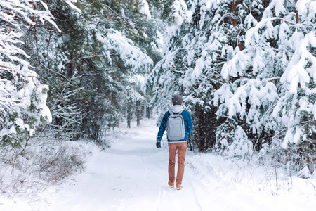 man walking alone in a beautiful snowy forest. Mental health concept