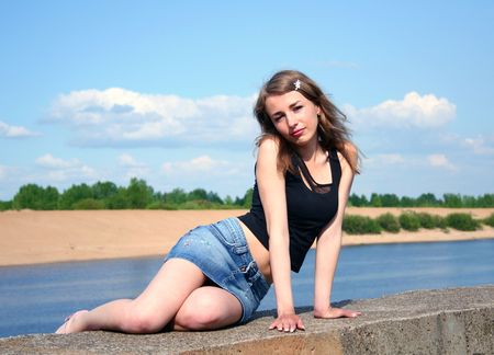 single girl on the stone near the riverの写真素材